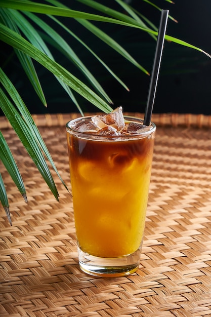 Zomerse gekoelde drankjes met vers sap op een rieten tafel met bladeren