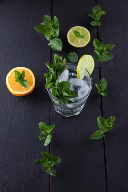 Zomerse gezonde limonadecocktails van met citrus doordrenkt water of mojito's met limoen, citroen, sinaasappel, ijs en munt Zelfgemaakte verfrissende limonade met plakjes citrus Close-up