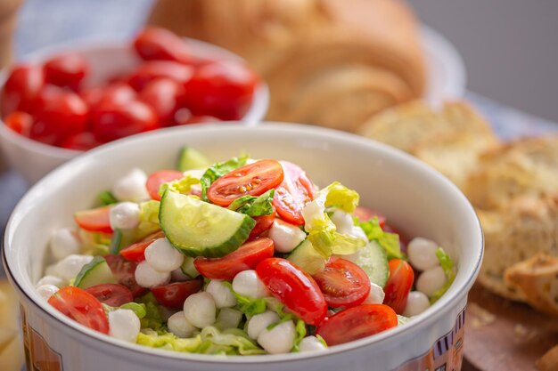 Zomerse salade. Frisse salade met mozzarella. Sla met cherrytomaatjes, komkommers en mozzarella.