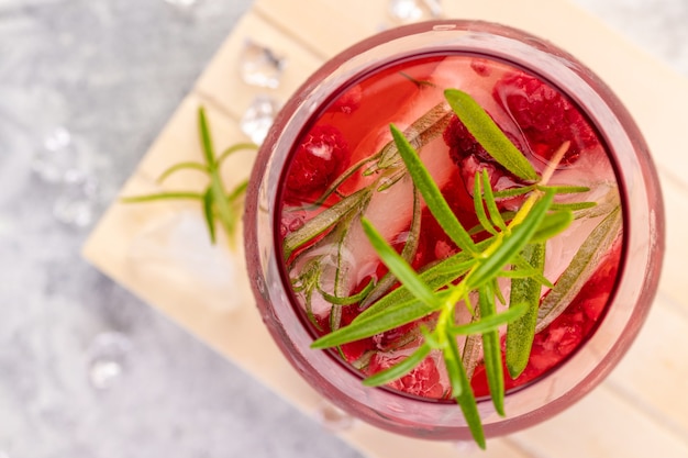 Zomerse verfrissende cocktails gemaakt van rose wijn of gin met frambozen en rozemarijn