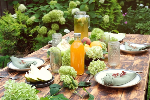 Zomertafelset Eettafel versierd met verse bloemen en fruit buiten