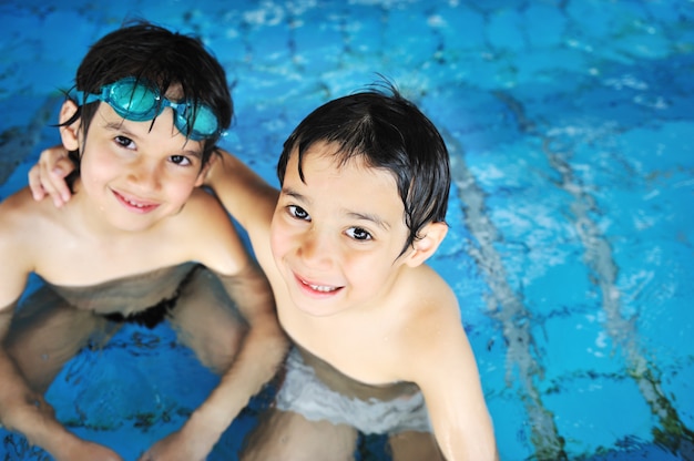 Zomertijd en zwemactiviteiten voor gelukkige kinderen bij het zwembad