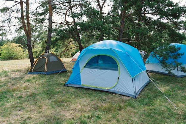 Foto zomertocht met kleurrijke tenten te midden van bosbomen.
