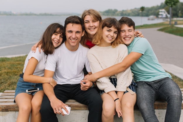 Zomervakantie en tienerconcept - groep glimlachende tieners die buiten hangen.
