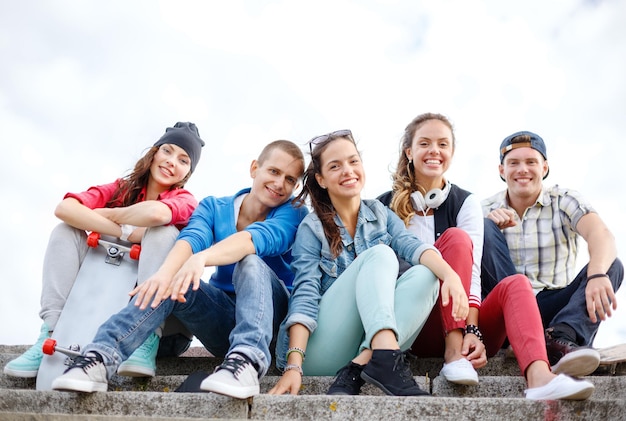 zomervakantie en tienerconcept - groep lachende tieners die buiten hangen