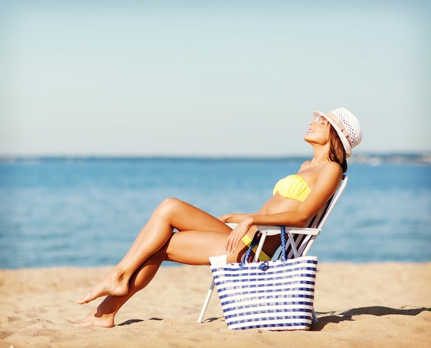 zomervakantie en vakantie - meisje in bikini zonnebaden op de strandstoel