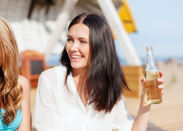 zomervakantie en vakantie - meisje met drankje en vrienden op het strand