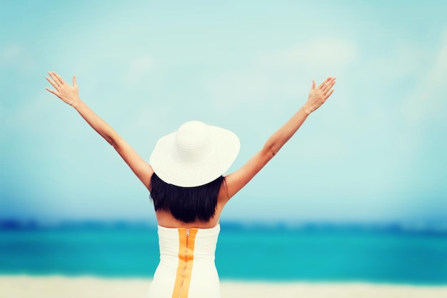 zomervakantie en vakantie - meisje met handen omhoog op het strand