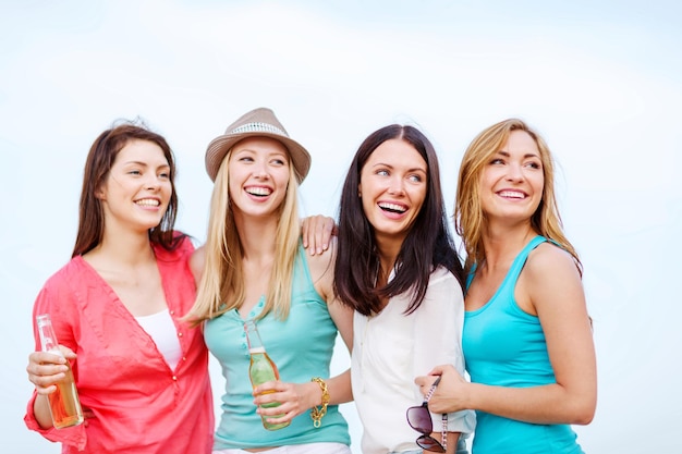 zomervakantie en vakantie - meisjes met drankjes op het strand