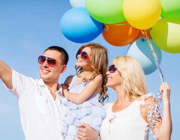 Zomervakantie, feest, kinderen en mensen concept - gezin met kleurrijke ballonnen