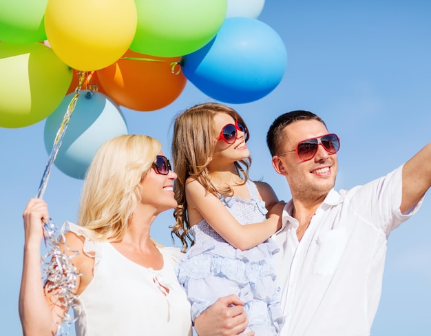 Foto zomervakantie, feest, kinderen en mensen concept - gezin met kleurrijke ballonnen