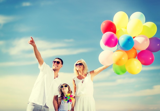 Zomervakantie, feest, kinderen en mensen concept - gezin met kleurrijke ballonnen