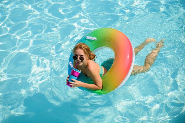 Zomervakantie genieten van zonnebrand vrouw in zwembroek op opblaasbare cirkel in het zwembad