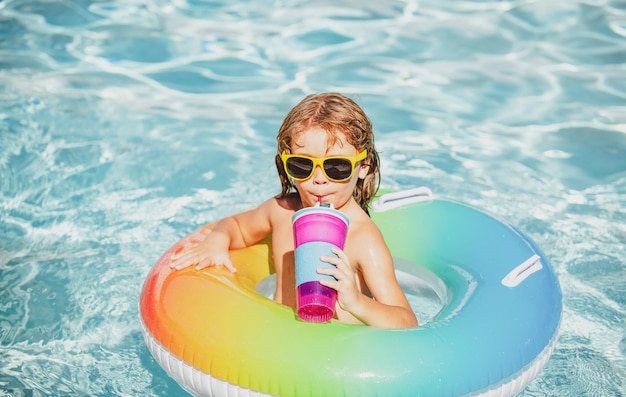 Zomervakantie Grappige kindjongen ontspannen in het waterpark cocktail drinken