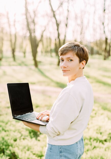 Zomervakantie in de laptop van de de holdingslaptop van de parkvrouw mededeling