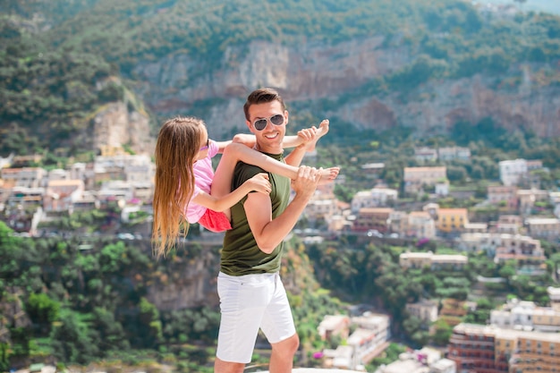 Zomervakantie in Italië. Jonge man en kind in Positano dorp op de achtergrond, Amalfi kust, Italië