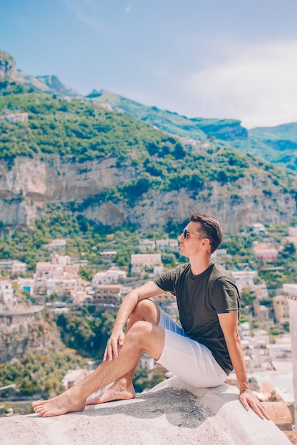 Zomervakantie in Italië. Jonge mens in Positano-dorp op de achtergrond, Amalfi Kust, Italië