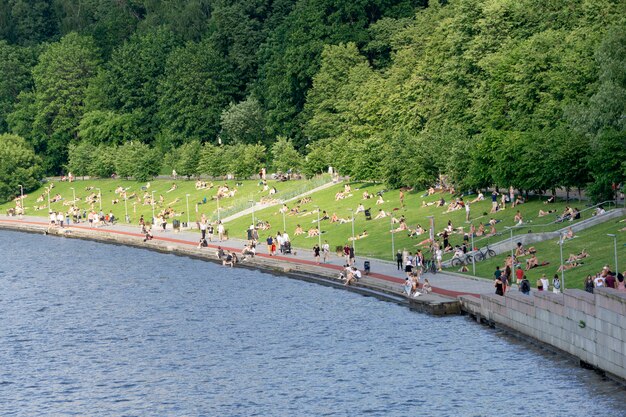 Zomervakantie in moskou. mensen zonnebaden op de dijk van de rivier de moskou in de zomer op een warme zonnige dag.