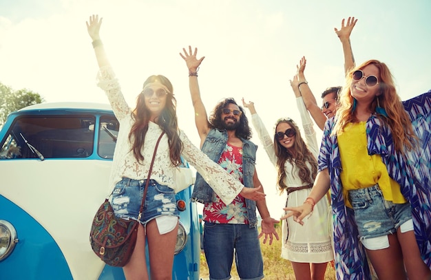 zomervakantie, roadtrip, vakantie, reizen en mensenconcept - lachende jonge hippievrienden die plezier hebben met een minivan-auto