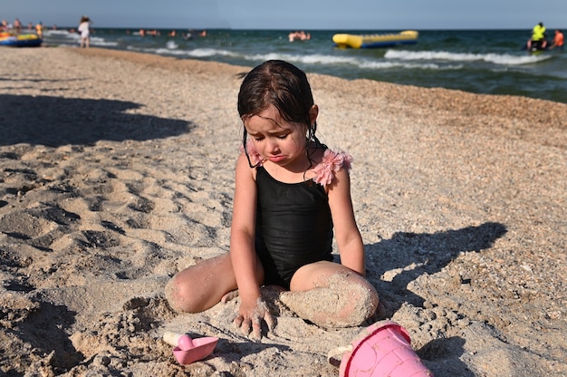 Zomervakantie Schattig peutermeisje spelen met strandspeelgoed op het zandstrand Zomervakantie c