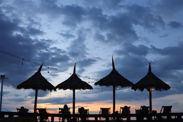 Zomervakantie sommige mensen ontspannen op het strand van een ligstoel en genieten van zonsondergang tijd kopiëren ruimte voor trav