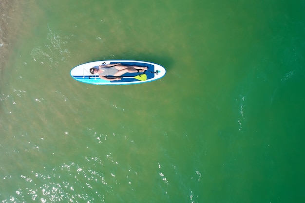 Zomervakanties Mooie jonge vrouw ontspannen op de SUP bij Turquoise Water Beauty Wellness Recreation