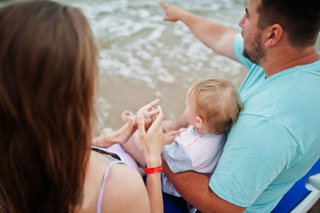 Zomervakanties Ouders en mensen buitenactiviteiten met kinderen Gelukkige familievakanties Vader zwangere moeder baby dochter zittend op zonnebank op zee zandstrand