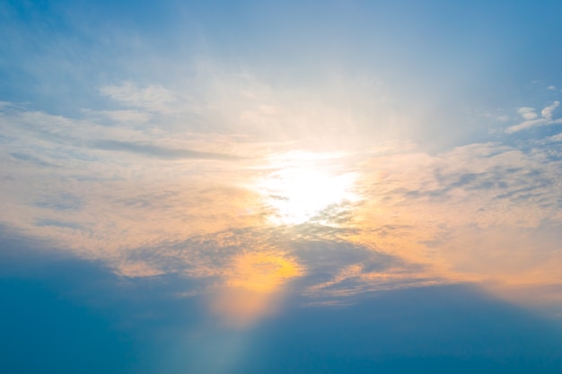 Zon in de wolken bij zonsondergang de zonnestraal verlicht de lucht in oranje