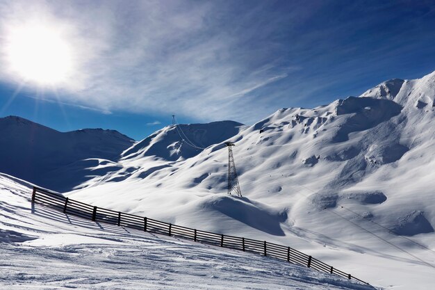 Zon over winterbergen bedekt met sneeuw. Koude zonnige winterdag in Oostenrijkse Alpen