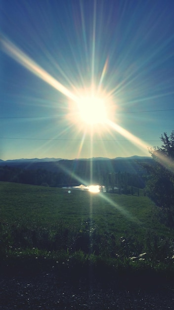 Foto zon schijnt door wolken over bergen.