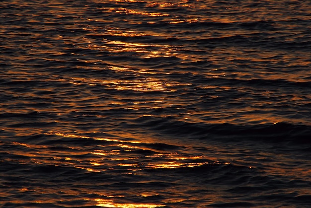 Zon weerkaatst de golven bij zonsopgang op zee