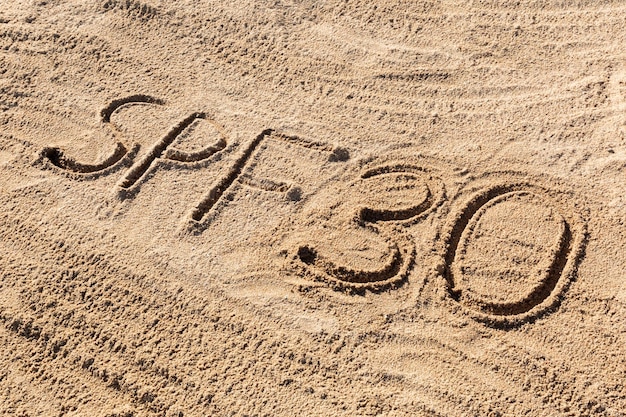 Zonbeschermingsfactor dertig concept SPF 30 woord geschreven op het strand