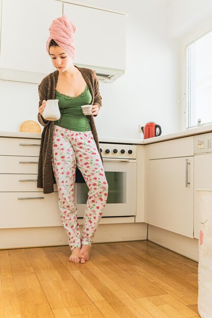 Zondagochtend van jonge vrouw met kopje koffie alleen