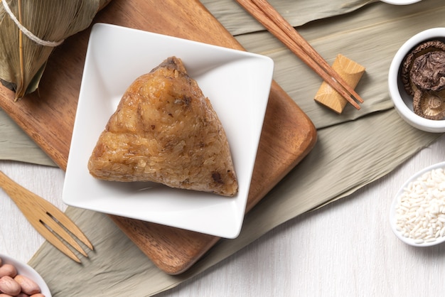 Zongzi. 나무 테이블 배경 상위 뷰를 통해 드래곤 보트 Duanwu 축제에 대한 맛있는 전통 쌀 만두 음식.