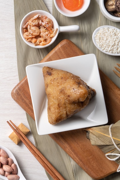 사진 zongzi. 나무 테이블 배경 상위 뷰를 통해 드래곤 보트 duanwu 축제에 대한 맛있는 전통 쌀 만두 음식.