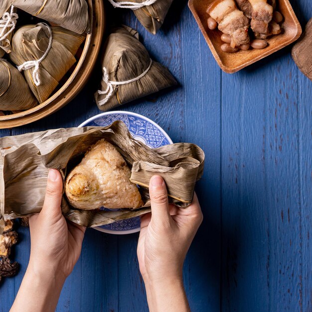 Zongzi Dragon Boat Festival concept Rice dumpling traditional Chinese food on blue wooden background for Duanwu Festival top view flat lay design concept