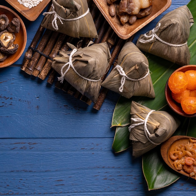 Zongzi dragon boat festival concept rice dumpling traditional
chinese food on blue wooden background for duanwu festival top view
flat lay design concept