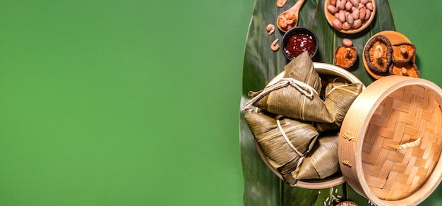 Zongzi gestoomde rijst dumplings op groene tafel achtergrond eten in Dragon Boat Festival duanwu concept close-up kopie ruimte bovenaanzicht plat lag