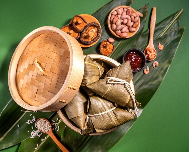 Zongzi, gestoomde rijstknoedels op groene tafelachtergrond, eten in duanwu-concept van het drakenbootfestival, close-up, kopie ruimte, bovenaanzicht, plat leggen