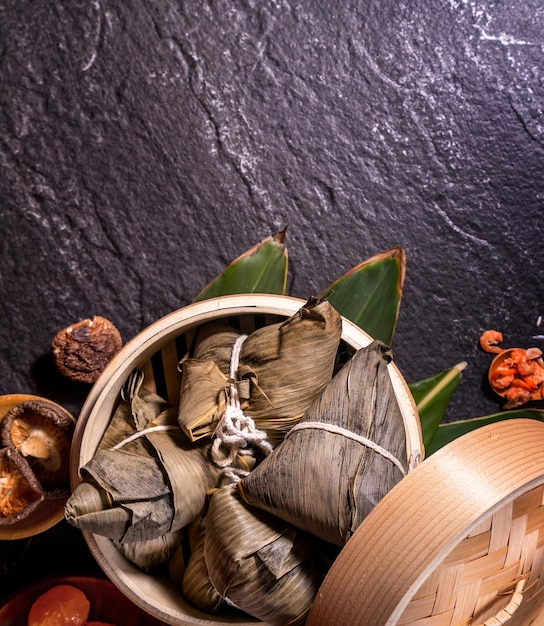 Zongzi heerlijke gestoomde rijst dumplings in stoomboot op zwarte achtergrond voor drakenboot duanwu festival close-up kopie ruimte bovenaanzicht plat lag