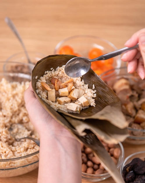 Zongzi maken - ingrediënt van chinese rijst knoedel zongzi maken op tafel thuis voor dragon boat festival viering, close-up, levensstijl.