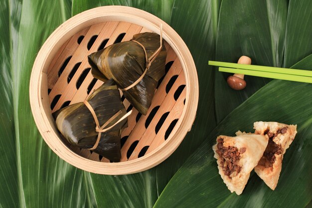 Zongzi of Bakcang, Chinese hartige kleverige rijstknoedels in het verpakken van bamboebladeren. Vers concept met verse Bakcang-bladeren.