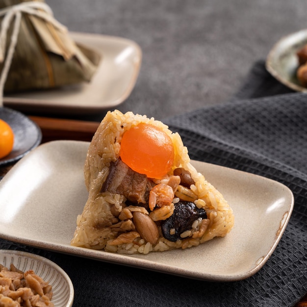Zongzi rice dumpling for Dragon Boat Festival on dark gray table background with ingredient