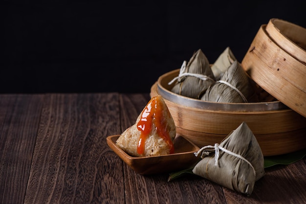 Zongzi rice knoedel voor chinese traditionele dragon boat festival duanwu festival op donkere houten tafel achtergrond