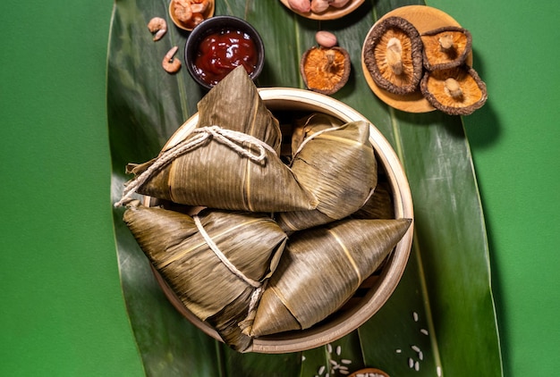 Zongzi steamed rice dumplings on green table background food in dragon boat festival duanwu concept close up copy space top view flat lay