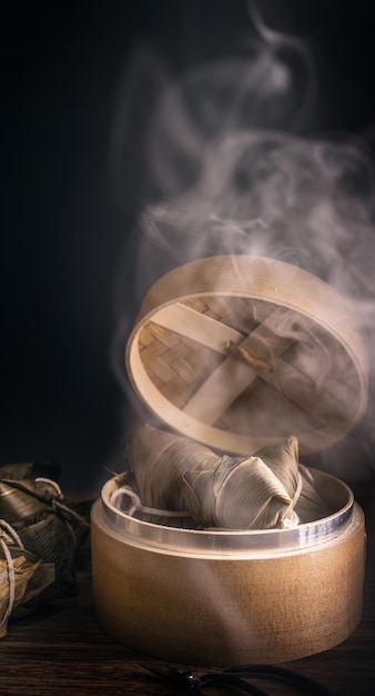 Zongzi steamed rice dumplings in steamer on wooden table famous tasty food in dragon boat festival duanwu design concept close up copy space