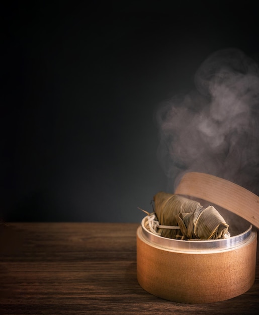 Zongzi steamed rice dumplings in steamer on wooden table famous tasty food in dragon boat festival duanwu design concept close up copy space