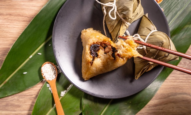 Zongzi vrouw eten gestoomde rijst dumplings op houten tafel voedsel in Dragon Boat Festival duanwu concept close-up kopie ruimte bovenaanzicht plat lag