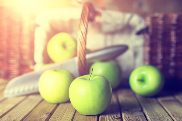 Zonlicht groene appel in een mand houten achtergrond