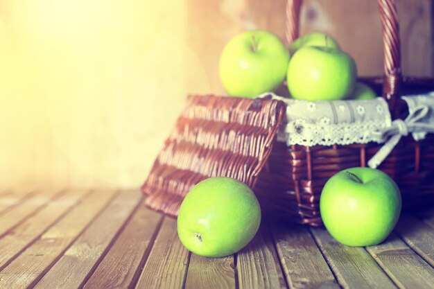 Zonlicht groene appel in een mand houten achtergrond